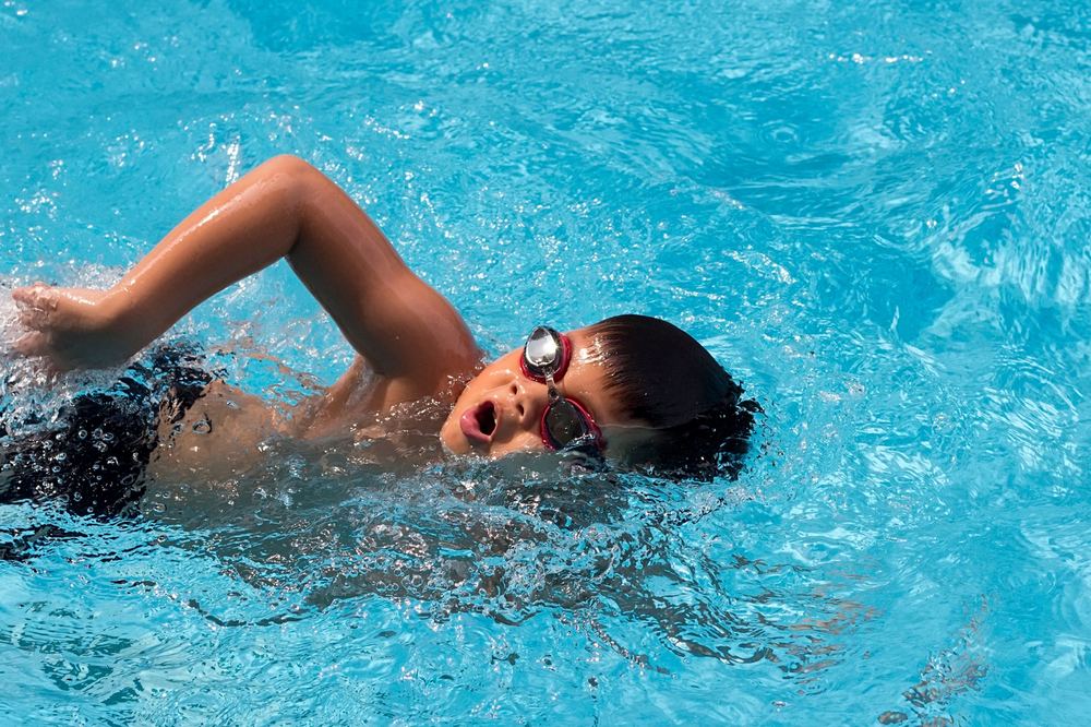 A young swimmer practising freestyle breathing