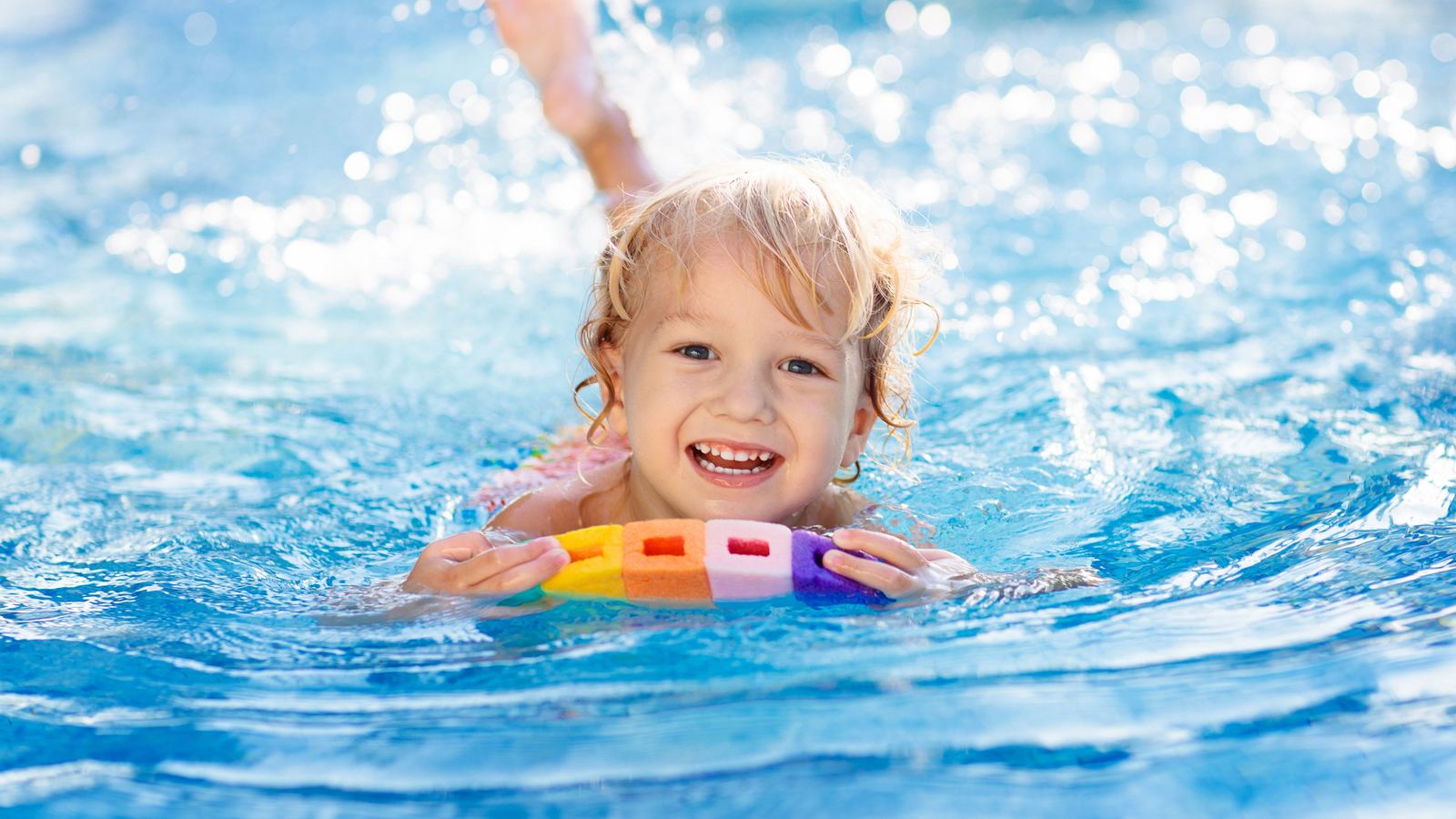 Group of happy swimmers cheering in the pool